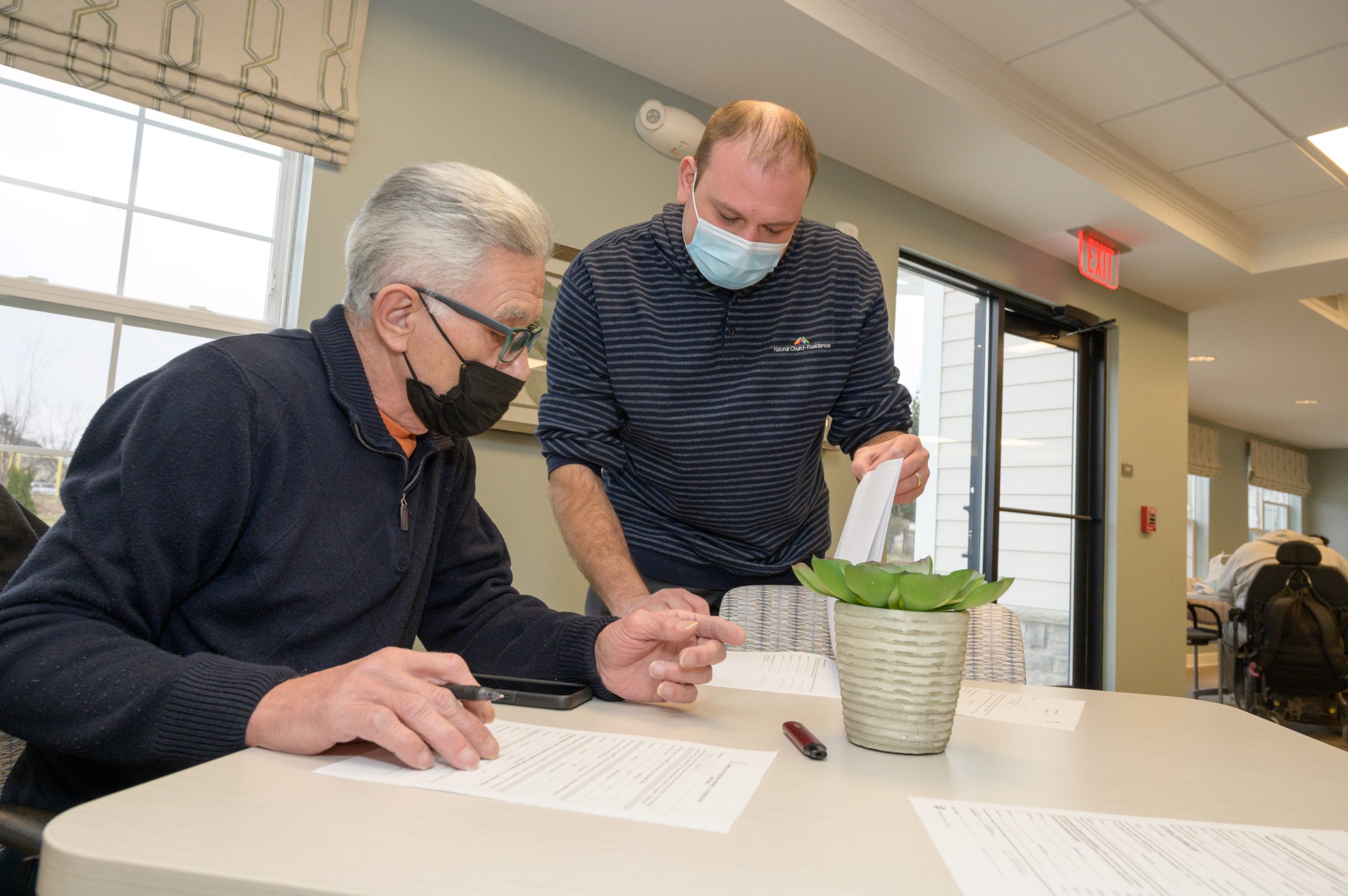 Senior men filling out forms in masks