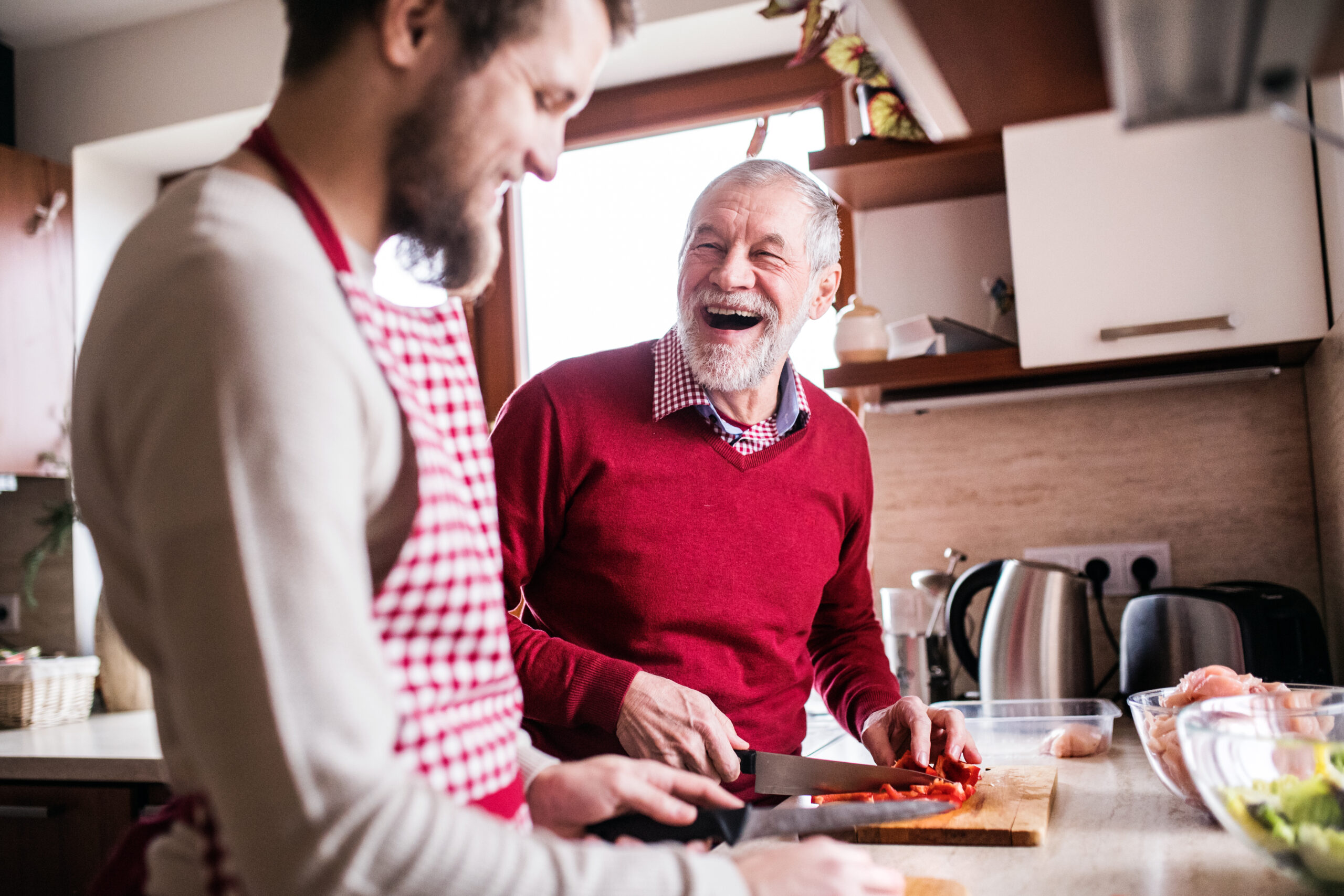 A man cooking with his dad as a fun thing to do with his elderly parents.