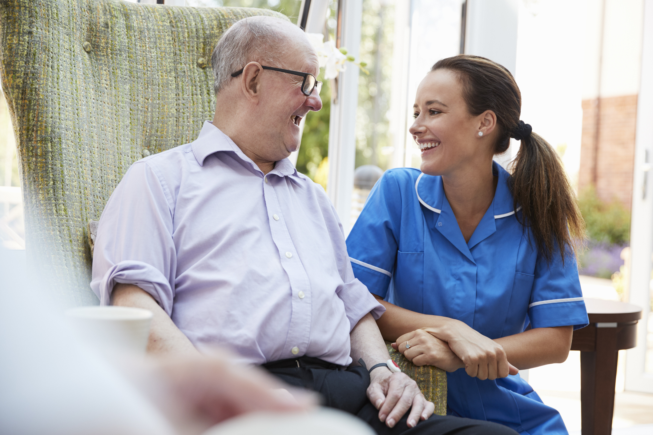 A care provider talking with a senior at a memory care facility.