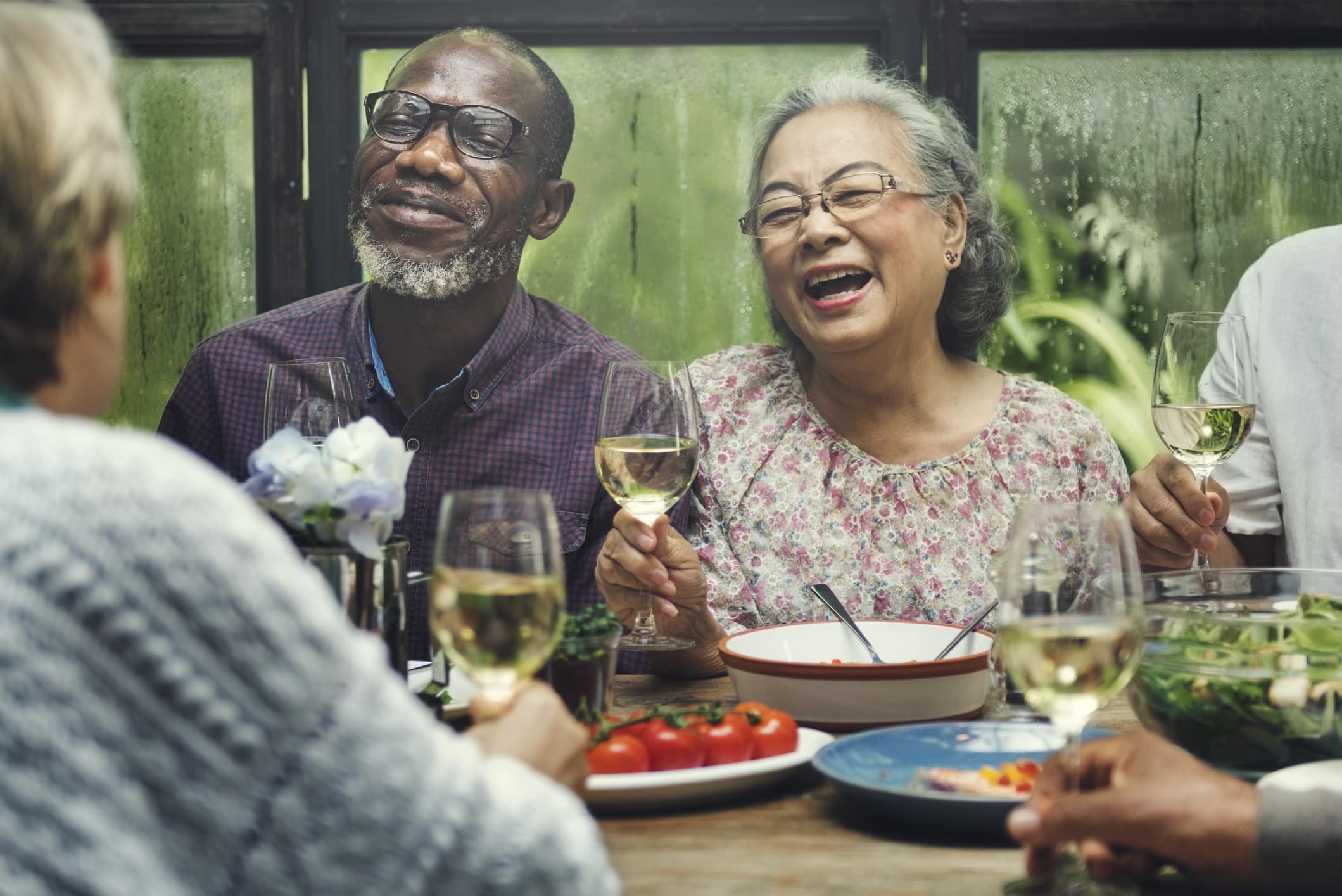 A group of seniors enjoying a meal at a restaurant on their independent living community campus.