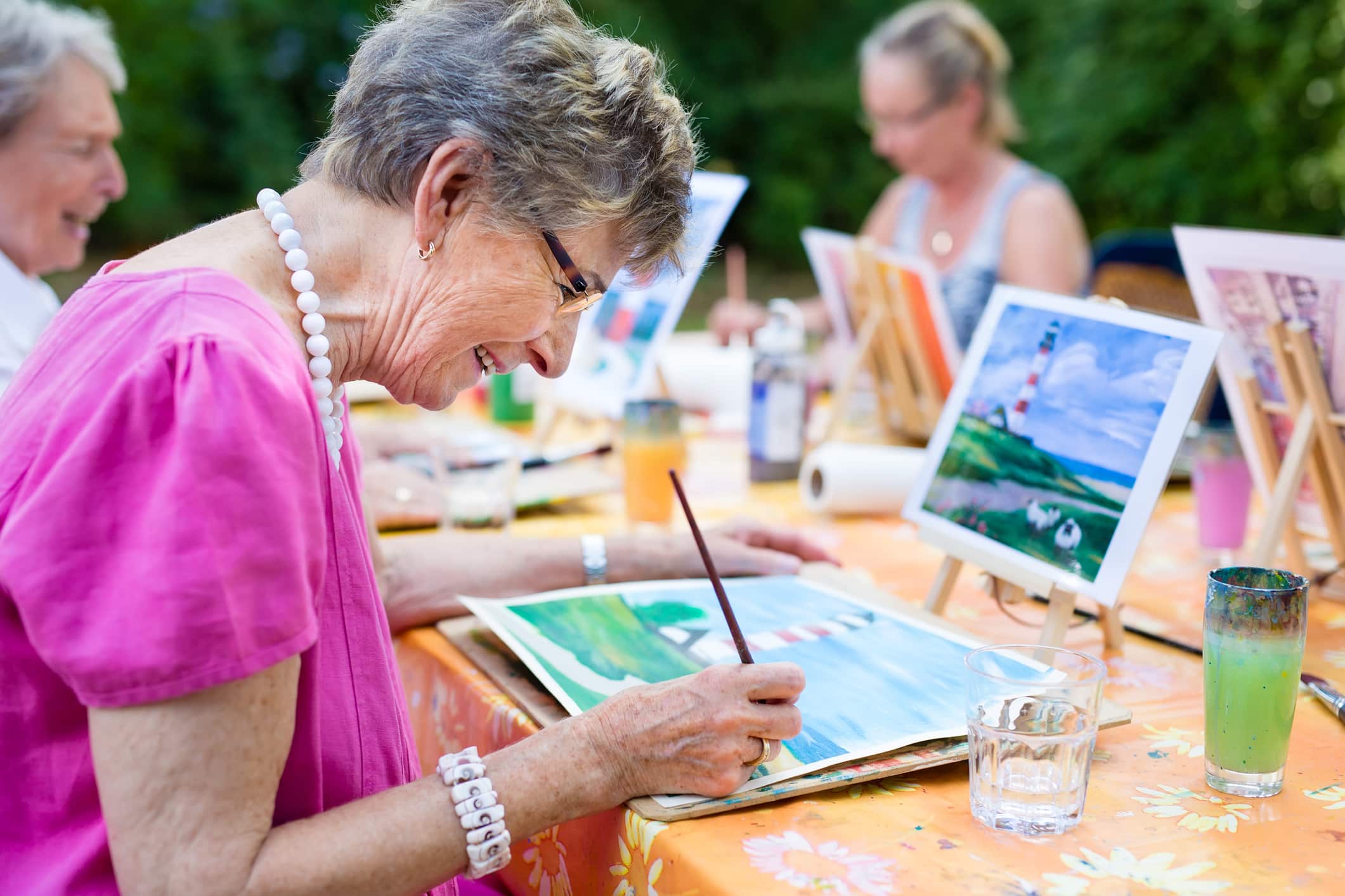 An older women with Alzheimer’s staying engaged with a water color painting class.